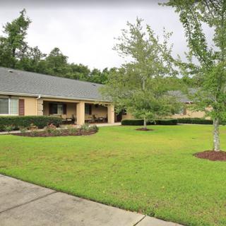 A suburban house with a well-maintained lawn and trees.