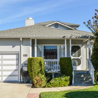 A suburban house with a porch and attached garage.