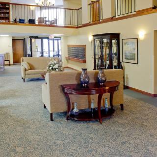 A spacious lobby interior with sofas, a wooden table, and decorative elements.