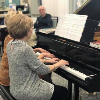 Two people playing a piano duet.