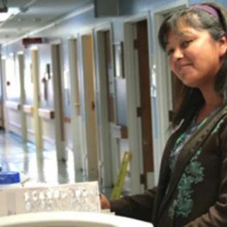 A woman standing in a hospital corridor.