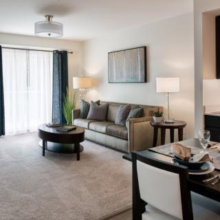A modern living room with a comfortable sofa, stylish coffee table, and a cozy dining area.