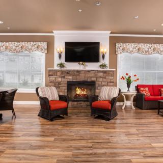 A cozy living room featuring a fireplace, comfortable seating, and a mounted television.