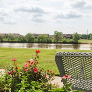 A serene view of a river bordered by lush greenery and vibrant flowers, perfect for relaxation.