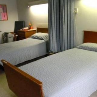 A hospital room with twin beds separated by a curtain.