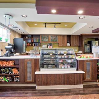 A modern cafe interior with a display case filled with snacks and baked goods.