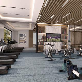 A modern gym with treadmills and exercise bikes in a spacious, well-lit interior.