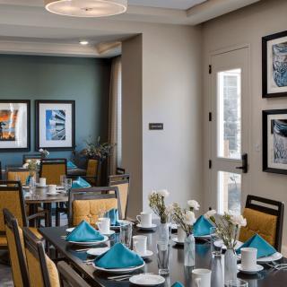 A modern dining room with neatly set tables and contemporary artwork on the walls.