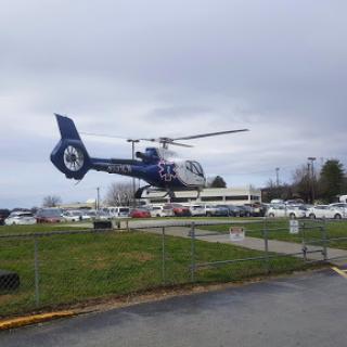 A helicopter in flight over a busy area, possibly related to emergency services.