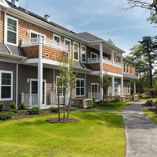 A well-maintained apartment complex with tidy landscaping and a paved pathway.