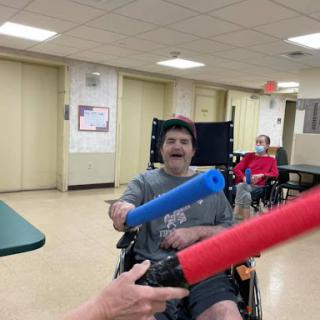 Participants enjoying a fun foam stick activity in an indoor setting.
