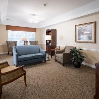 A cozy living room with a blue sofa, chairs, and warm lighting.