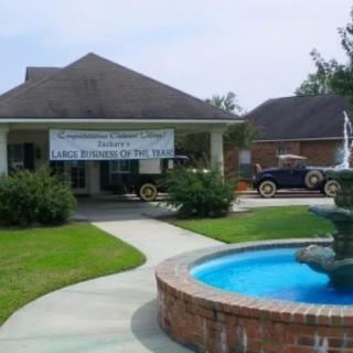 A house with a banner, vintage car, and a fountain in the front yard.
