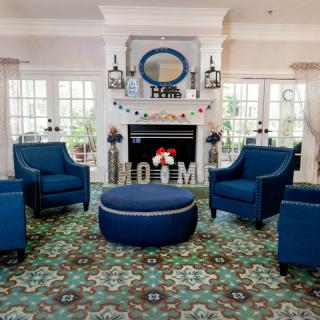 A cozy living room with elegant blue chairs and a stylish fireplace.