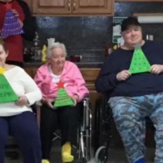 A group of seniors sitting indoors, holding festive decorations.