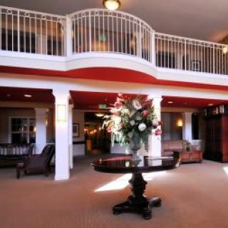 Elegant hotel lobby with a central flower arrangement and stylish furnishings.