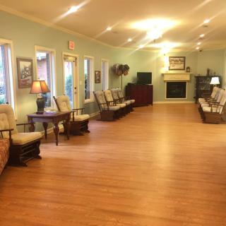 A spacious living room with comfortable seating, lamps, a television, and a fireplace.