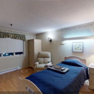 A neatly arranged bedroom with a bed, chair, and wall decorations.