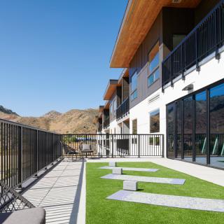 A modern building with a spacious balcony overlooking a mountainous landscape.