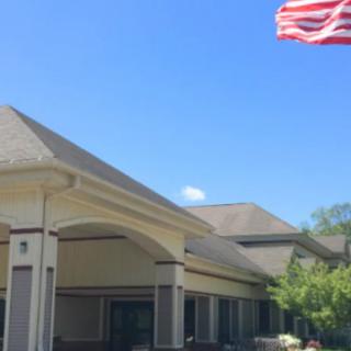 A building with a United States flag flying against a clear blue sky.