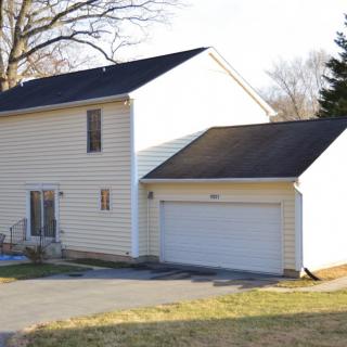 A two-story suburban house with an attached garage and driveway.