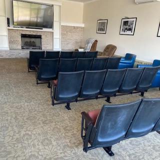 A waiting room with rows of chairs facing a television.