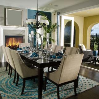 Elegant dining room with a modern design featuring a fireplace and an artfully set table.