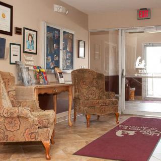 A cozy waiting area with patterned chairs, wall art, and reading materials.