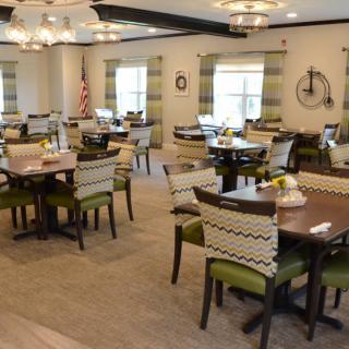 A well-lit dining room with tables and chairs arranged neatly.