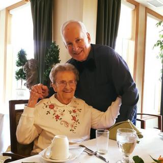 An elderly couple enjoying a meal together at a dining table.