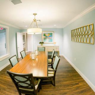 A stylish dining room with a wooden table, matching chairs, and elegant lighting.