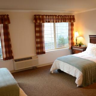 A cozy hotel room with twin beds and warm lighting.