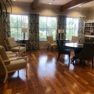 A cozy living room with comfortable seating, large windows, and a wooden floor.