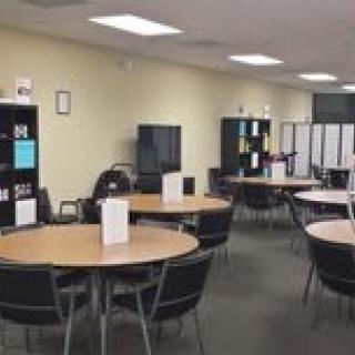 A spacious office area with round tables and chairs arranged for meetings.