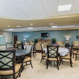 A spacious and well-lit dining room with neatly arranged tables and chairs.