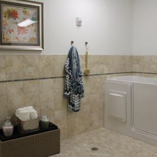 A tidy bathroom with a laundry area, featuring neatly hung towels and decorative art.