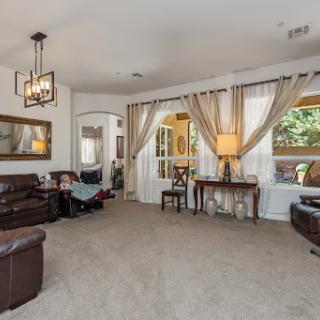 A cozy and well-lit living room featuring comfortable furniture and elegant decor.
