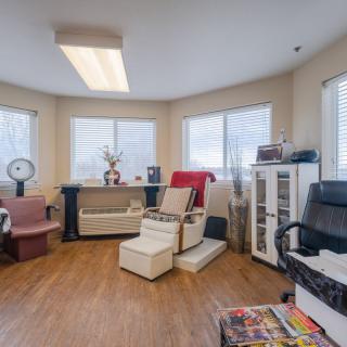 A cozy salon interior with multiple chairs and large windows offering a relaxing atmosphere.