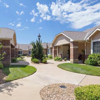 A well-maintained residential community with neatly arranged houses and lush landscaping under a clear blue sky.