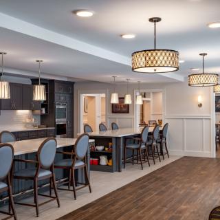 A modern kitchen and dining area with stylish lighting and comfortable seating.