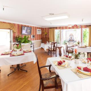 Elegant dining room with neatly set tables and warm, inviting decor.