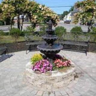 A charming garden fountain surrounded by colorful flowers and benches.