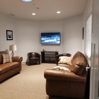 A cozy living room setup featuring a television, comfortable seating, and soft lighting.