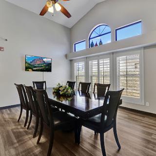 A spacious and modern dining room featuring a large table, comfortable chairs, and elegant windows that let in natural light.