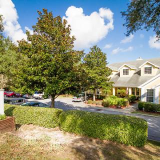 A charming house with well-maintained landscaping under a clear blue sky.