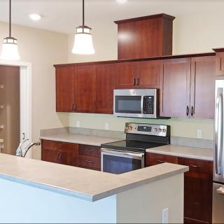 Modern kitchen with dark wood cabinets and stainless steel appliances.
