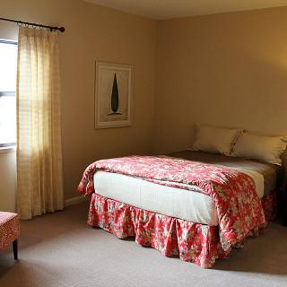A cozy bedroom with a neatly made bed and soft lighting.