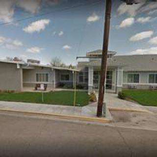 A suburban residential building with a lawn on a clear day.