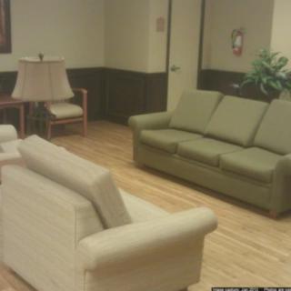 A quiet waiting room with a green sofa and a beige couch.