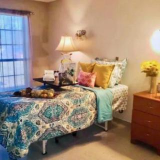 A cozy bedroom with colorful bedding and soft, warm lighting.